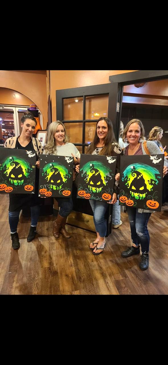Women holding Halloween canvases
