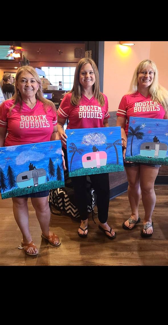 Three friends showing off their paintings