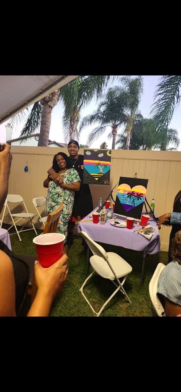 Couple posing with finished paintings