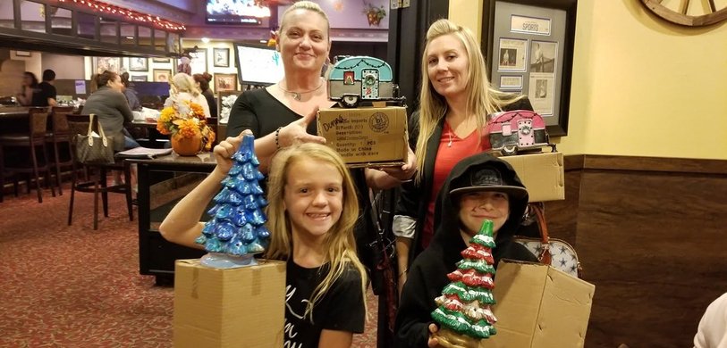 Family holding their painted ceramic Christmas trees