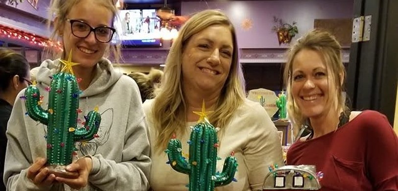 Three women with painted ceramic cactus and camper pieces